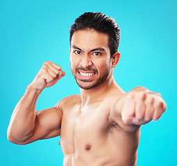 Image showing Man, shirtless and martial arts in studio portrait with power, punch and anger by blue background. Guy, mma and muscle for fight, contest or sport with exercise, training and workout for competition