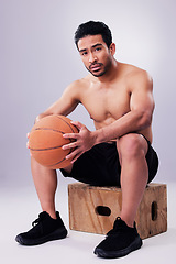 Image showing Portrait, fitness and basketball with a man on a box in studio on a gray background for training or a game. Exercise, workout or mindset and a young male sports athlete holding a ball with focus