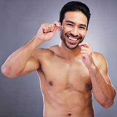 Image showing Teeth cleaning, floss and studio portrait of happy man with oral hygiene, self care or tooth treatment string. Mouth plaque routine, aesthetic smile and person with dental product on gray background