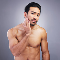 Image showing Portrait, skincare and man with beauty, cosmetics and frustrated against a grey studio background. Face, male person and model with grooming routine, unhappy and facial with wellness, shine and sad