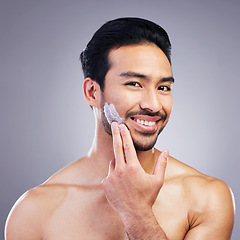 Image showing Cosmetics, skincare or portrait of happy man with face cream or sunscreen product in grooming routine. Dermatology, studio background or confident Asian model smiling or applying facial creme lotion