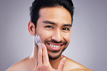 Image showing Smile, portrait or happy man with shaving cream or beard product in grooming routine with cosmetics. Beauty, studio background or Asian male model applying hair removal creme lotion for skincare