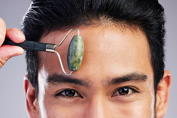 Image showing Man, portrait or face massage with roller or quartz product for healthy skincare on studio background. Forehead, crystal stone treatment or male model with facial dermatology cosmetic for beauty glow