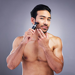 Image showing Beard hair, trimmer and portrait of man with bathroom routine, wellness grooming and cosmetics skincare. Morning face cleaning, facial growth maintenance and studio person shaving on grey background