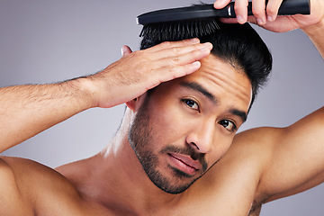 Image showing Portrait, beauty or man brushing hair in grooming with salon haircare product on studio background. Natural person, brush or confident healthy Asian male model with cool hairstyle in morning routine