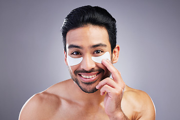 Image showing Portrait, skincare or happy man with eye patch for beauty or wellness isolated on studio background. Cosmetics, smile or model with facial collagen pads or dermatology product for anti aging or glow