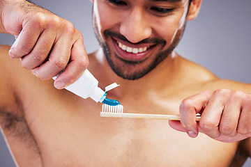 Image showing Toothpaste, dental or happy man brushing teeth with smile or healthy oral hygiene grooming in studio. Eco friendly, tube product or male model cleaning mouth with a natural bamboo wood toothbrush