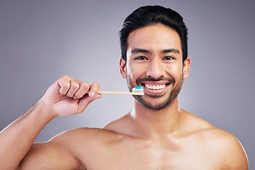 Image showing Smile, portrait and a man brushing teeth on a studio background for cleaning, grooming and hygiene. Happy, wellness and an Asian person with a toothbrush for care of mouth isolated on a backdrop