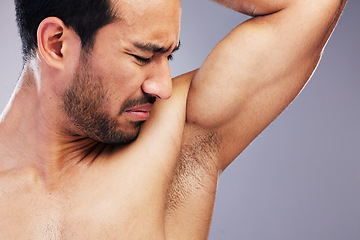 Image showing Armpit, stink and man with body odor in studio isolated on a white background for deodorant, cleaning and skincare cosmetic. Underarm, bad smell and model with hyperhidrosis, sweating or poor hygiene