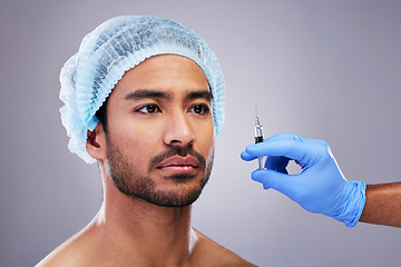 Image showing Hand, face and plastic surgery with a man in studio on a gray background for silicon injection. Facelift, beauty and transformation with a male customer in a clinic for antiaging filler or cosmetics