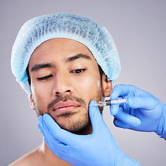 Image showing Hands, face and plastic surgery with a man in studio on a gray background for a botox injection. Needle, beauty and transformation with a male customer in a clinic for antiaging filler or cosmetics