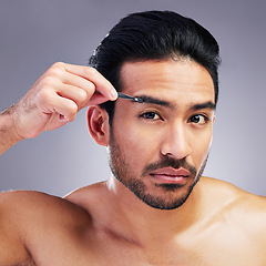 Image showing Tweezer, eyebrow and portrait of a man in studio for beauty, hygiene or grooming. Facial hair removal, epilation and face of asian person for skincare, self care and cosmetic tools on grey background