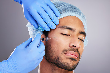 Image showing Hands, implant and plastic surgery with a man in studio on a gray background for a silicon injection. Face, beauty and transformation with a male customer in a clinic for antiaging dermatology filler