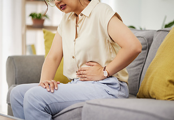 Image showing Sick woman, sofa and stomach pain for health, digestion and nausea of pms at home. Closeup of female person, menstruation and abdomen bloating of constipation, period and endometriosis in living room