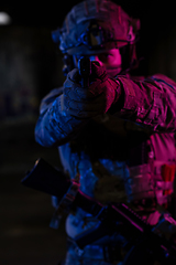 Image showing Soldier of army elite forces, special security service fighter with hidden behind mask and glasses face, in helmet and load carriage system, aiming with service pistol low key.