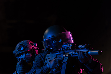 Image showing Modern warfare soldiers in dark with combat ammunition and weapons in the hands of equipped laser sights are in battle order. Mixed media.