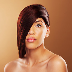 Image showing Hair care, portrait and a young woman in studio for salon, hairdresser and wellness results. Beauty, cosmetics and shampoo for growth and shine of a serious model person on a brown background