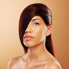 Image showing Hair care, beauty and portrait a young woman in studio for salon, hairdresser and wellness results. Glow, cosmetics and shampoo for growth and shine of serious model person on a brown background