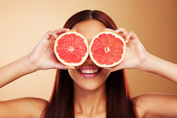 Image showing Beauty, grapefruit and a woman with skin care in studio for natural dermatology, cosmetics or wellness. Facial, fruit and healthy diet for detox or nutrition of model person on a brown background