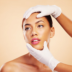 Image showing Hands, plastic surgery or facelift for woman in studio ready for laser, filler implant or beauty transformation. Skincare consultation, facial or gloves for change or liposuction on brown background