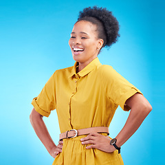 Image showing Happy, laughing and a black woman in studio with funny humor, confidence and a positive mindset. Fashion, hands in hips and african female model person in casual clothes on a blue background