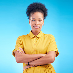 Image showing Arms crossed, portrait and a black woman in studio with fashion, confidence and a positive mindset. Pride, smile and african female model person in casual clothes on a blue background for motivation