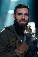 Image showing Army soldier in Combat Uniforms with an assault rifle and combat helmet night mission dark background. Blue and purple gel light effect.