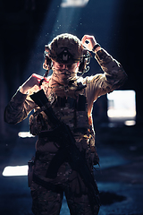 Image showing Army soldier in Combat Uniforms with an assault rifle and combat helmet night mission dark background. Blue and purple gel light effect.