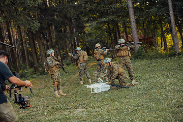 Image showing Modern Warfare Soldiers Squad are Using Drone for Scouting and Surveillance During Military Operation in the Forest.