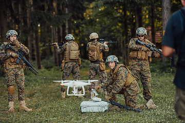 Image showing Modern Warfare Soldiers Squad are Using Drone for Scouting and Surveillance During Military Operation in the Forest.