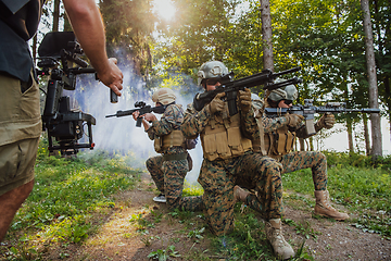 Image showing Videographer with Professional Movie Video Camera Gimbal Stabilizing Equipment Taking Action Shoot of Soldiers in Action in Forest