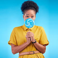 Image showing Happy, candy and portrait of a black woman on a studio background for a lollipop, excited and eating. Freedom, young and an African girl or model with sweets for a snack isolated on a backdrop