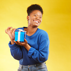 Image showing Gift, winning and happy black woman with a surprise isolated in a yellow studio background for a birthday. Giveaway, box and excited person to celebrate, party and holiday as a winner with happiness