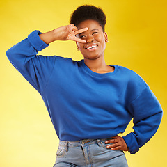 Image showing Hand sign, peace and a black woman in studio with a smile, confidence and a positive mindset. Emoji, icon and happy african female model person on yellow background with a v symbol and freedom