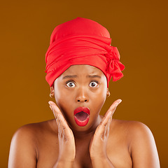 Image showing Portrait, surprise and black woman with makeup, cosmetics or head wrap against a brown studio background. Face, female person or model shocked, creative and dermatology with news, self care and shine