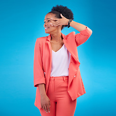 Image showing Fashion, smile and confident with a black woman on blue background in studio posing in a suit for style. Runway, clothes and happy young female model standing in a trendy outfit for a magazine cover