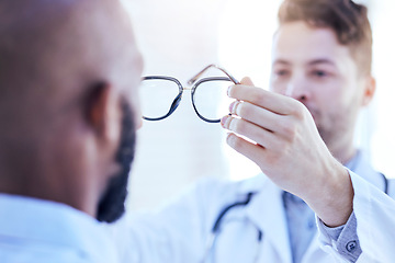 Image showing Hands, man and optometrist with glasses for eye support and lens check at a doctor consultation. Medical, wellness and back of patient with vision and eyewear care with professional holding frame