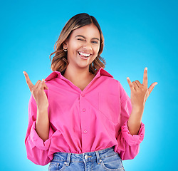 Image showing Wink, portrait and woman with rocker hands in studio for freedom, happy and positive attitude on blue background. Smile, face and female with rockstar emoji, sign or punk gesture, good mood or vibes