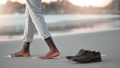 Image showing Shoes, feet and beach for business man, freedom and sunset to relax in nature by water after work. Person, ground and ocean with barefoot adventure for holiday, outdoor and steps on sand at dusk