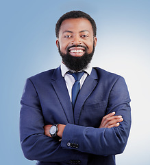 Image showing Happy, crossed arms and portrait of businessman in a studio with success, confidence and leadership. Smile, professional and headshot of a young, smart and African lawyer isolated by blue background.