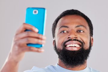 Image showing Happy black man, face and selfie in photography for social media, vlog or networking against a grey studio background. African male person smile for photo, memory or online communication and picture