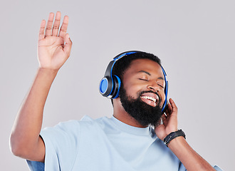 Image showing Headphones, sing and man in a studio with music, playlist or album while dancing with energy. Happy, smile and young African male model listening to a song or radio online isolated by gray background