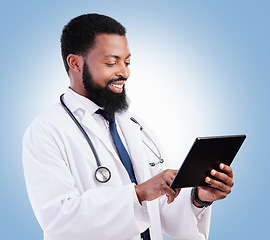 Image showing Healthcare, tablet and a black man doctor on a blue background in studio for cardiology research. Medical, technology and innovation with a male medicine professional reading information online