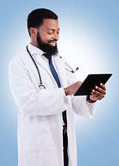 Image showing Medical, tablet and a black man doctor in studio on a blue background for cardiology research. Healthcare, technology and innovation with a male medicine professional searching for information online