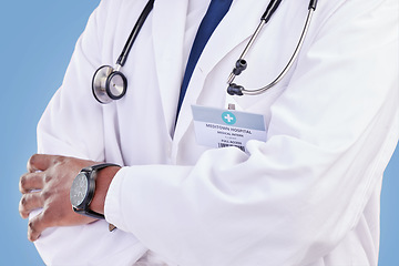 Image showing Doctor, stethoscope and arms crossed in studio with a medical expert or healthcare worker on blue background. Surgeon, hands and confidence in medicine or pharmaceutical research in hospital