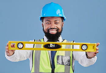 Image showing Happy black man, portrait and architect with level for measuring in construction against a blue studio background. African male person, engineer or contractor smile holding tool for measurements