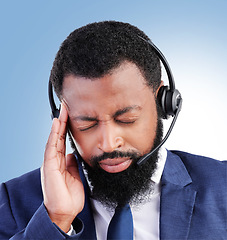 Image showing Customer service, studio face and black man headache, stress or sad over telecom fail, salesman crisis or call center burnout. Mental health risk, migraine pain and African person on blue background