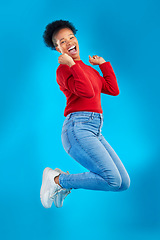 Image showing Excited, jump and woman portrait with winner, deal and smile in a studio. Wow, energy and up in the air with female person and blue background with celebration for sale announcement and big news