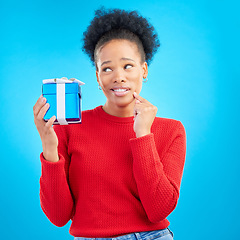 Image showing Thinking, winner and black woman with a present, box and celebration against a blue studio background. Female person, doubt or model with a gift, giveaway product or package with surprise and curious