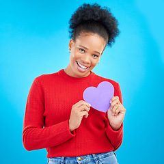 Image showing Woman, portrait and heart cut out with a smile for love and valentines day in studio. African female person, blue background and romance emoji icon for kindness with a young happy model and paper